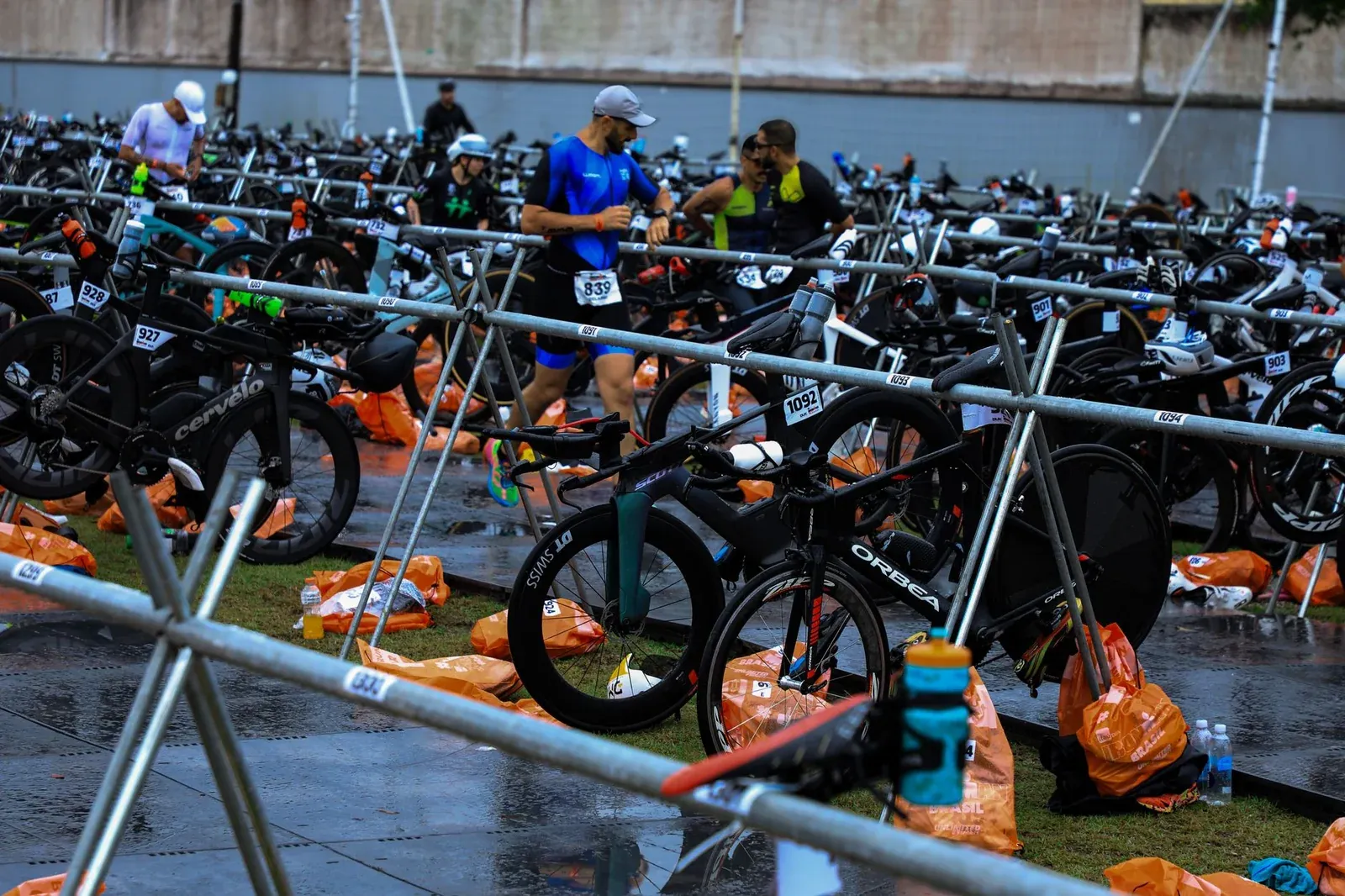 Un athlète court dans un parc à vélos en regardant sa montre.